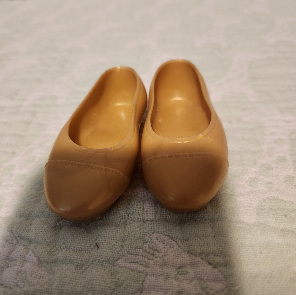 Pair of gold Geoffrey Doll flats shoes.